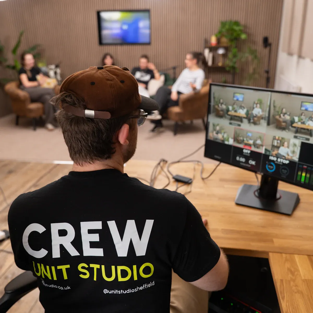 Unit Studio crew member directing a multi-camera podcast recording from the production desk